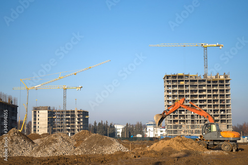 Photos Bucked wheel excavator digs ground at a construction site for installing concrete storm pipes