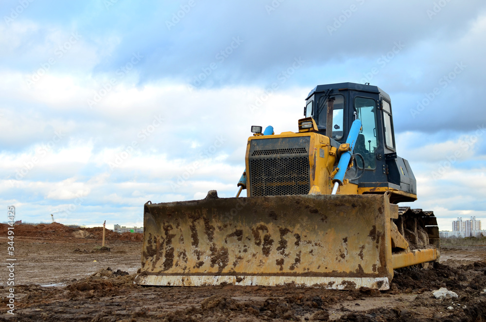 Bulldozer during of large construction jobs at building site. Land clearing, grading, pool excavation, utility trenching and foundation digging. Crawler tractor, dozer, earth-moving equipment. Bulldozer during of large construction jobs at building site. Land clearing, grading, pool excavation, utility trenching and foundation digging. Crawler tractor, dozer, earth-moving equipment.