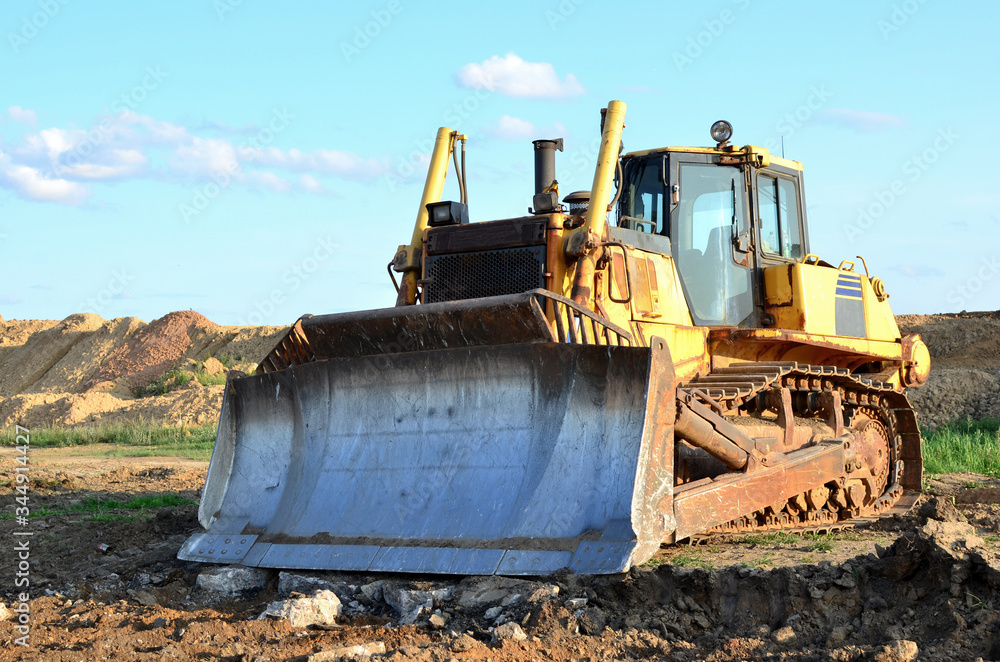 Bulldozer with bucket for pool excavation and utility trenching. Dozer during demolition concrete and asphalt at construction site. Earth-moving equipment for land clearing and foundation digging. Bulldozer with bucket for pool excavation and utility trenching. Dozer during demolition concrete and asphalt at construction site. Earth-moving equipment for land clearing and foundation digging.