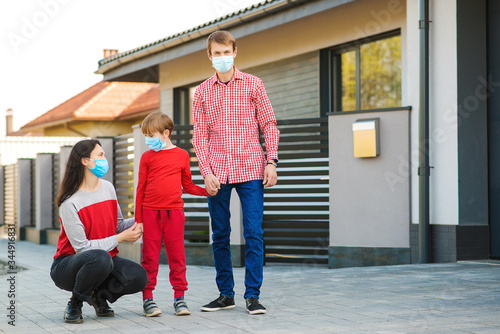 Safety mask to protect coronavirus outbreak. Prevention coronavirus. Son with parents going for a walk. Family wearing face mask.