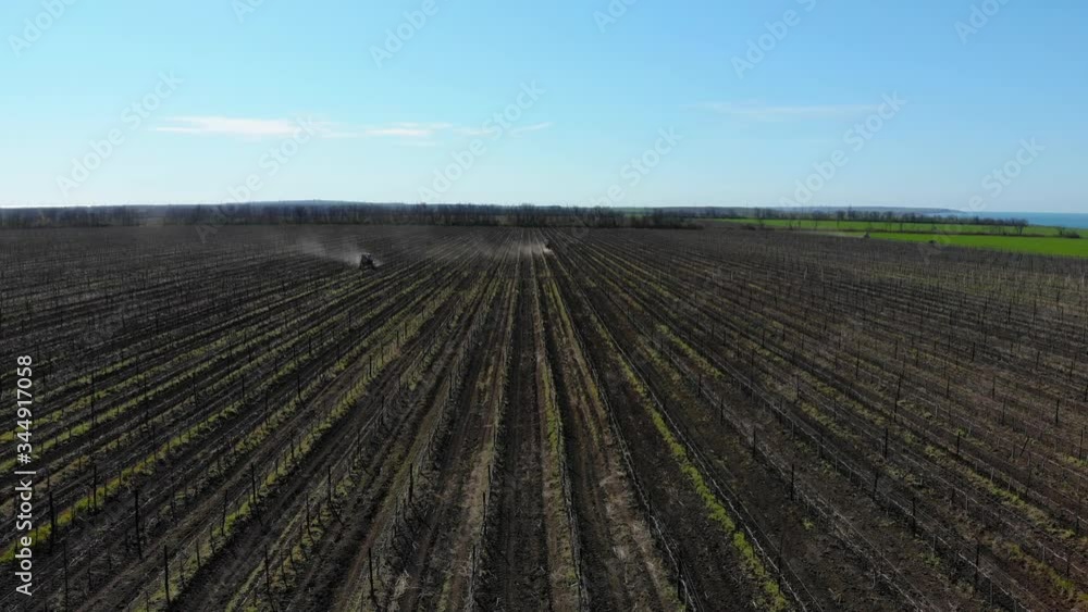 Agriculture concept. Two tractors plow the land, Kuban vineyards, view from the top, 4K. Agriculture concept. Two tractors plow the land, Kuban vineyards, view from the top, 4K.