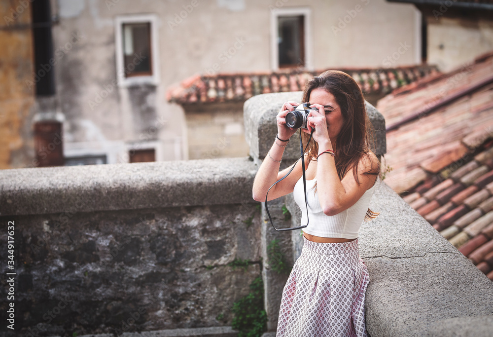 Beautiful tourist with vintage camera around the streets of the center.