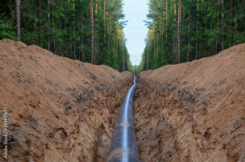 Сonstructing pipelines that transport oil, natural gas, petroleum products and industrial gases. A dug trench in the ground for the installation of industrial gas and crude pipes. photo