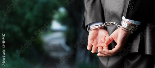 Male hands in handcuffs behind his back © BillionPhotos.com