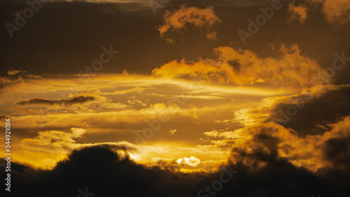 Dramatic clouds illuminated rising of sun floating in sky to change weather. Soft focus, blurred motion. Majestic cloudscape image ready for design, replace sky in photo editor. Meteorology background