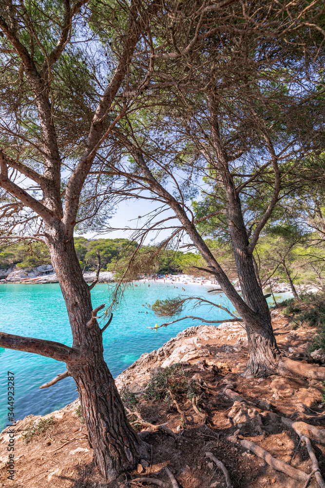 View of the famous beach Cala Turqueta. (Focus on foreground, people on the beach in blur). Menorca, Balearic islands, Spain