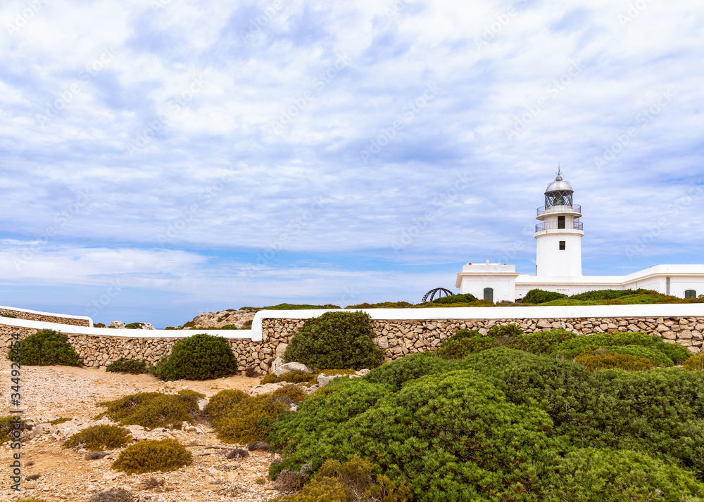 Beautiful view of the lighthouse (Faro de Cavalleria) and the cloudy sky above it. Menorca, Balearic islands, Spain