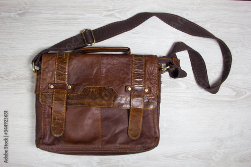 men's clothing worn wooden backgroundbrown leather men's bag. men's clothing worn wooden background photo