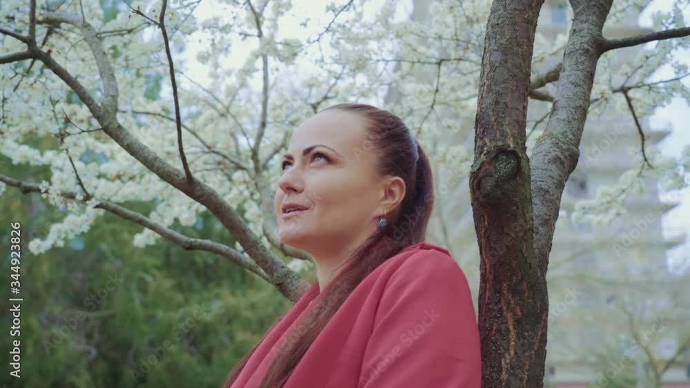 middle-aged couple talking in the park,white flowering under the tree,they held hands,clouse up,woman in red dress middle-aged couple talking in the park,white flowering under the tree,they held hands,clouse up,woman in red dress