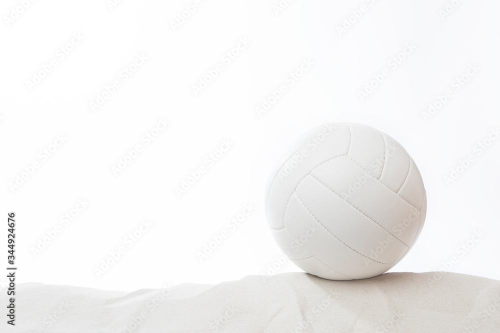 White volleyball in the sand on white background White volleyball in the sand on white background