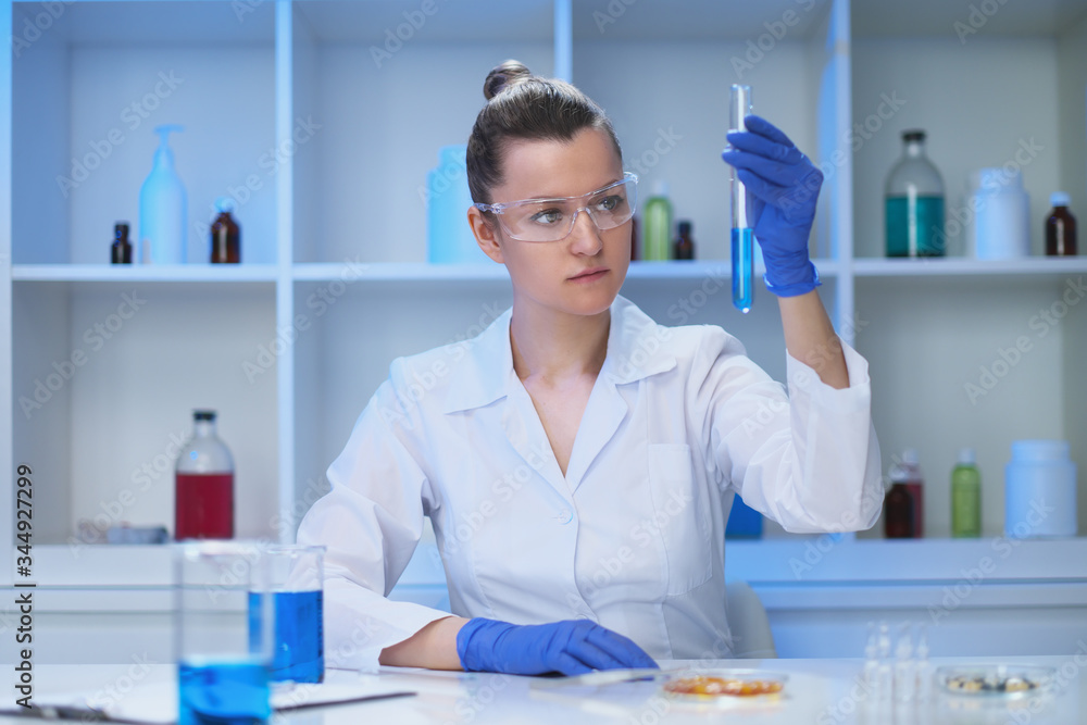 A female medical scientist works in a laboratory. Spcialist conducts experiments, develops auccin auctin from the virus. Coronavirus covid-19. A female medical scientist works in a laboratory. Spcialist conducts experiments, develops auccin auctin from the virus. Coronavirus covid-19.