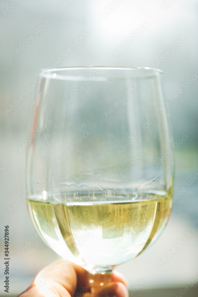 glass of white wine in female hand, selective focus glass of white wine in female hand, selective focus