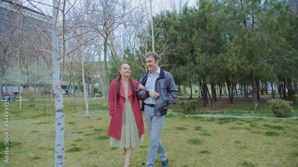 middle-aged couple walking in the park,The woman is dressed in red, middle-aged couple walking in the park,The woman is dressed in red,