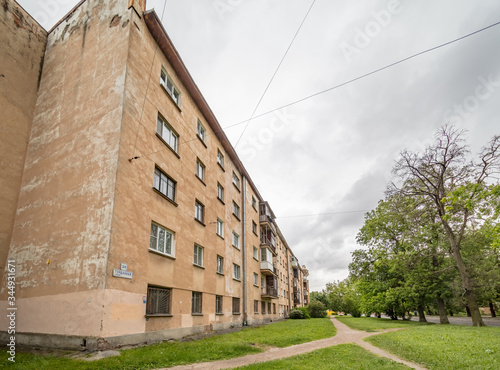 Old apartment house on green meadow in summer
