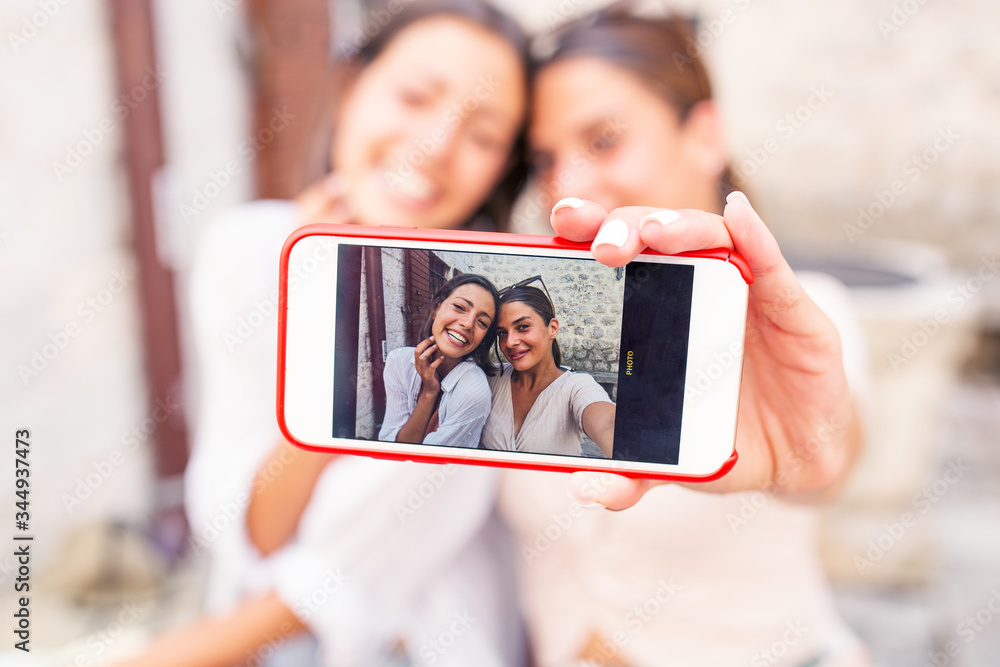 Cheerful female friends taking selfie
