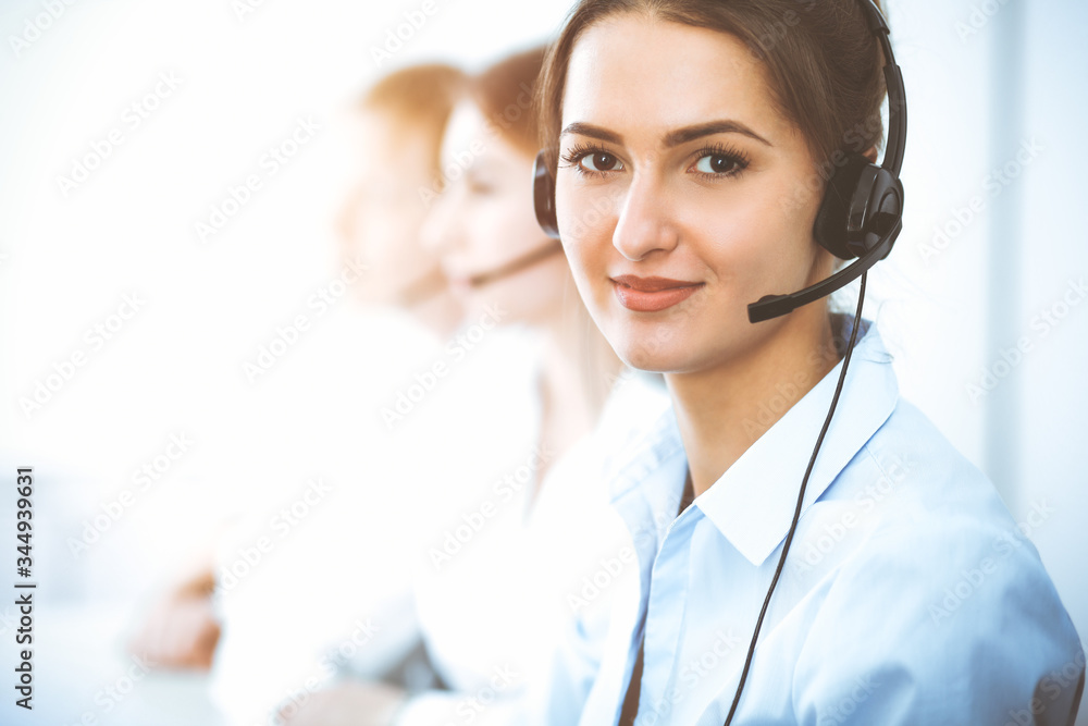 Call center operators. Focus on beautiful business woman using headset Call center operators. Focus on beautiful business woman using headset