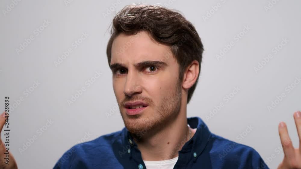 Displeased guy gesturing with hands. Annoyed man posing in studio Displeased guy gesturing with hands. Annoyed man posing in studio
