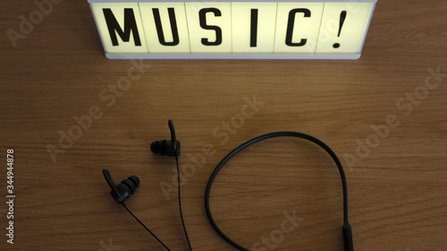 bluetooth earphones on wood with illuminated sign