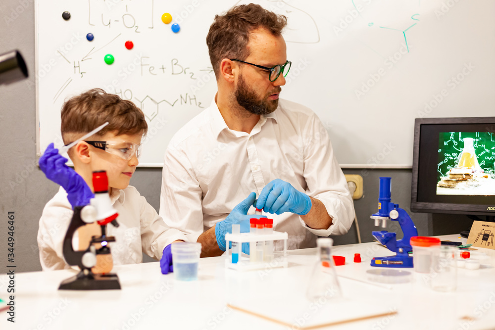 dad and son conduct experiments in a makeshift lab at home dad and son conduct experiments in a makeshift lab at home