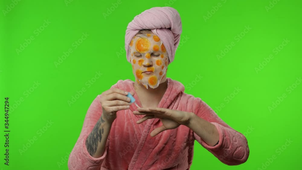 Transsexual man in bathrobe with face mask painting his hand nails. Chroma key Transsexual man in bathrobe with face mask painting his hand nails. Chroma key