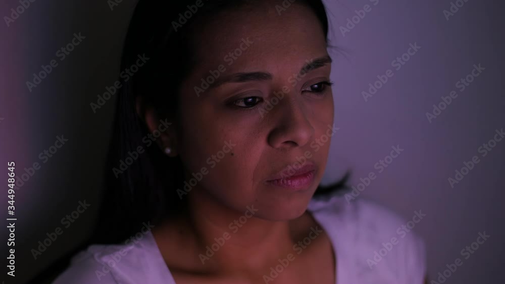 Close-up of a young woman watching tv, her face being colored by the content, side view Close-up of a young woman watching tv, her face being colored by the content, side view