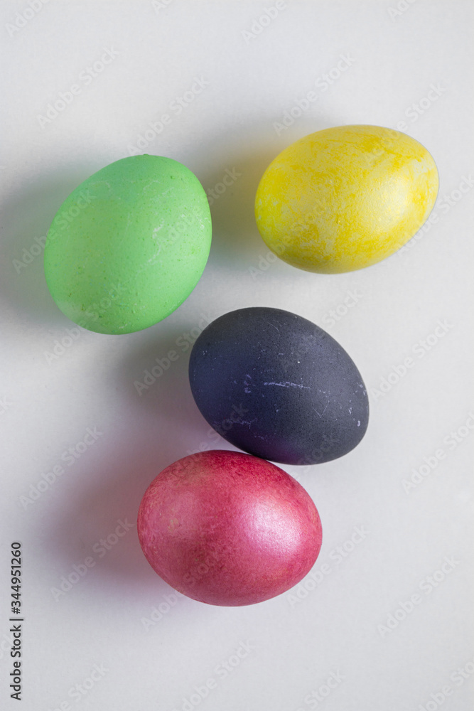 Easter festive multi-colored mother-of-pearl chicken eggs lay on a white background Easter festive multi-colored mother-of-pearl chicken eggs lay on a white background