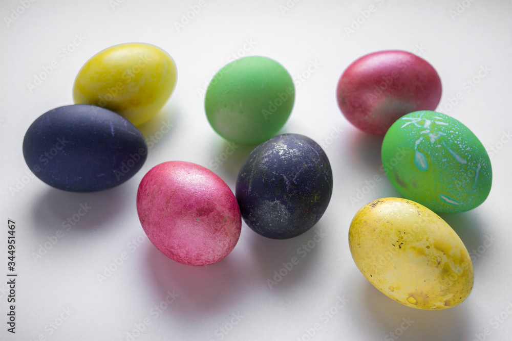 Easter festive multi-colored mother-of-pearl chicken eggs lay on a white background Easter festive multi-colored mother-of-pearl chicken eggs lay on a white background