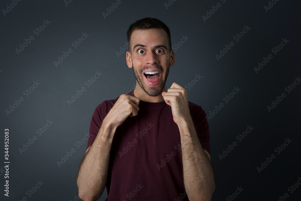 Fototapeta premium Human face expressions and emotions. Portrait of young desperate man looking panic, holding his hands near his face, with mouth wide open. Male in despair and shock