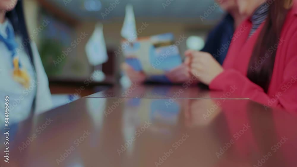 The girl who works at the reception gives the key to the hotel room,The lady in the red dress takes the key, The girl who works at the reception gives the key to the hotel room,The lady in the red dress takes the key,