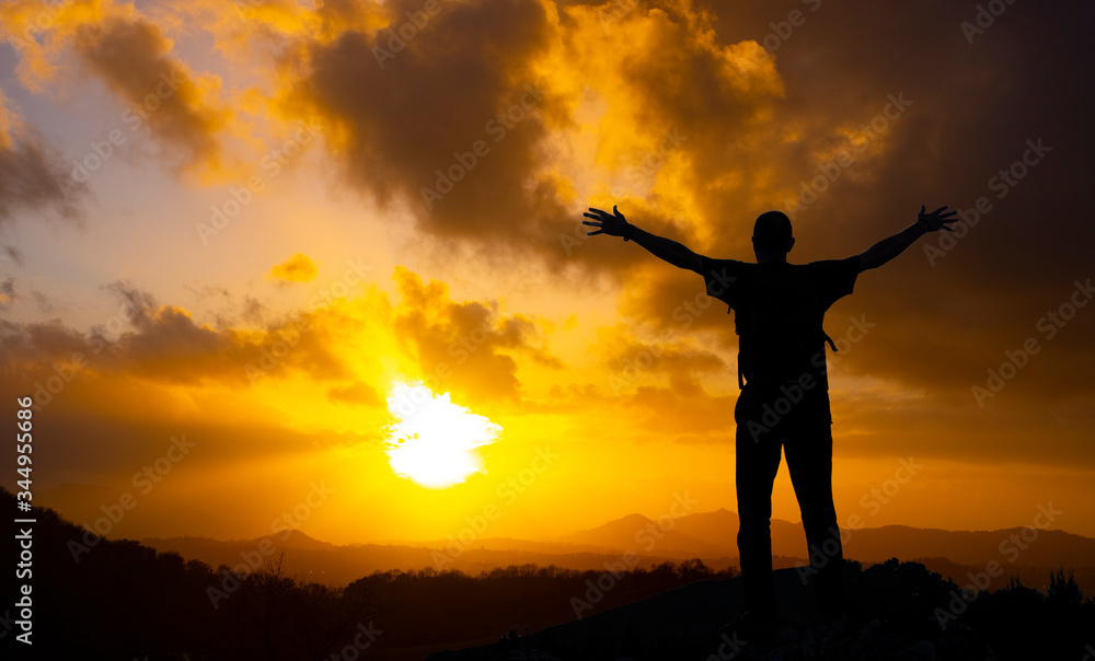 Man on top of mountain at sunset. Conceptual scene.