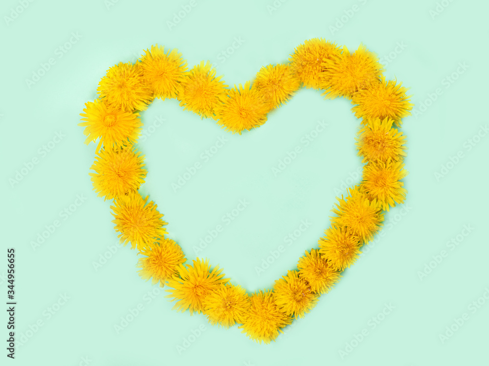 Heart-shaped dandelion flowers on a green background with space for text. 