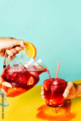Man pouring sangria punch in glass