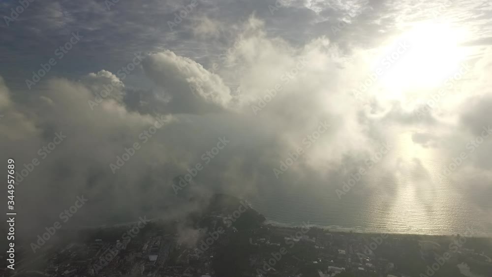 panoramic view from a drone on the coast with sunbeams breaking through the clouds, below is a green landscape with a forest and a village panoramic view from a drone on the coast with sunbeams breaking through the clouds, below is a green landscape with a forest and a village