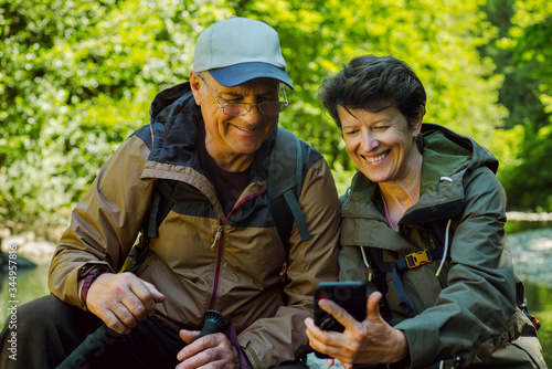 Smiling couple of travelers taking selfie by smartphone