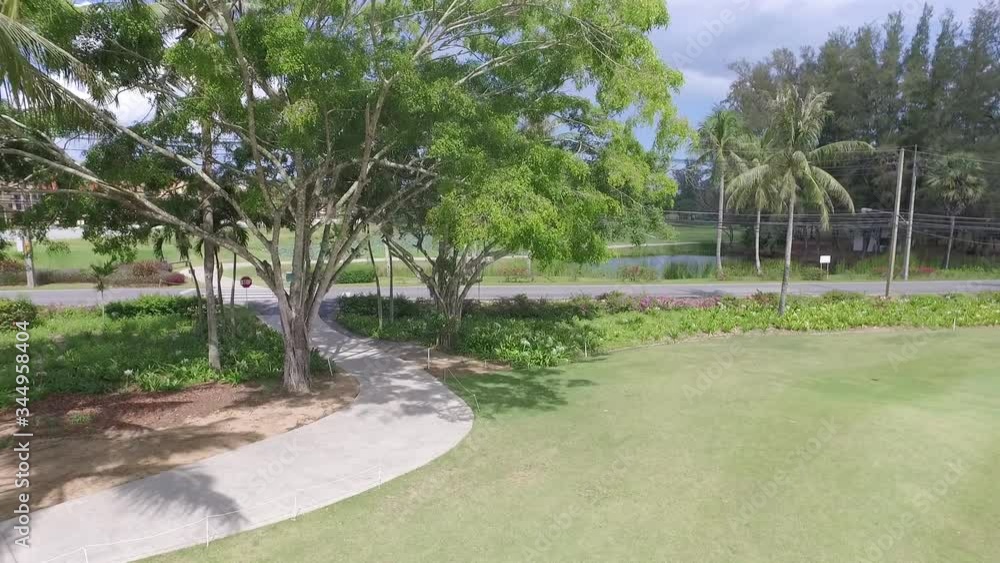 view from the drone of a golf course with approach to the road with a car and flowers along the road view from the drone of a golf course with approach to the road with a car and flowers along the road