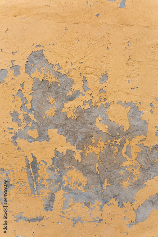 worn concrete patches on a yellow wall. worn concrete patches on a yellow wall.