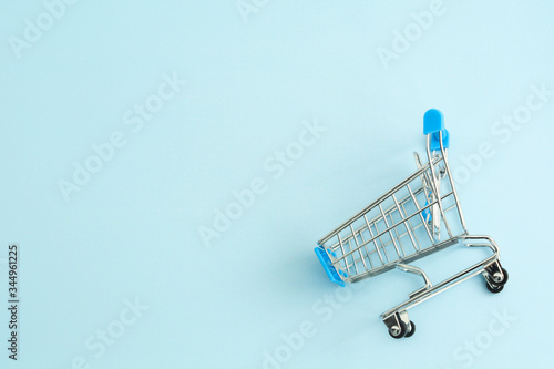 Small supermarket grocery push cart for shopping trendy fashion background. Sale buy mall market shop consumer concept photo