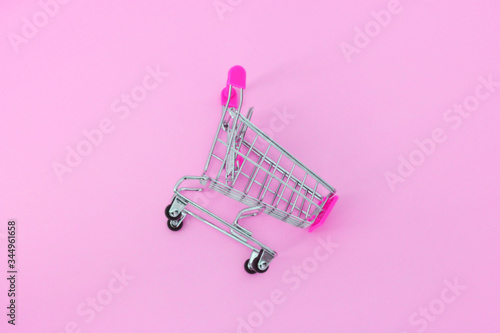 Small supermarket grocery push cart for shopping trendy fashion background. Sale buy mall market shop consumer concept photo