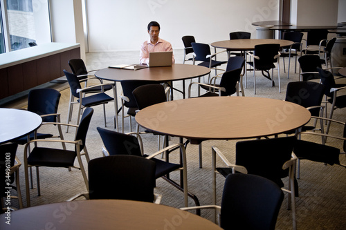 Businessman working on laptop in office cafeteria