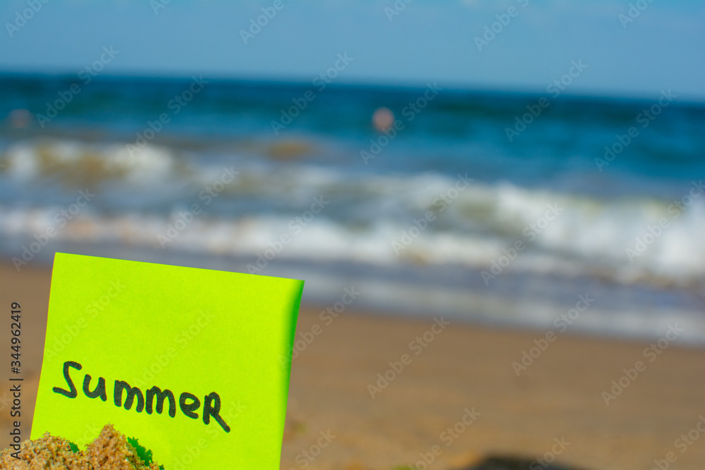 Naklejka premium Summer. Sandy beach. On the sand is a stationery with the inscription 