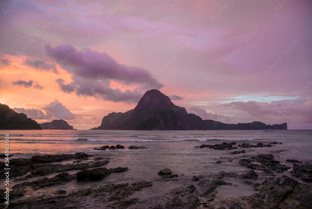 pink sun set over the rock islands of el nido philippines