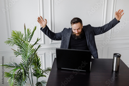Portrait of amazed man with laptop computer over white background.