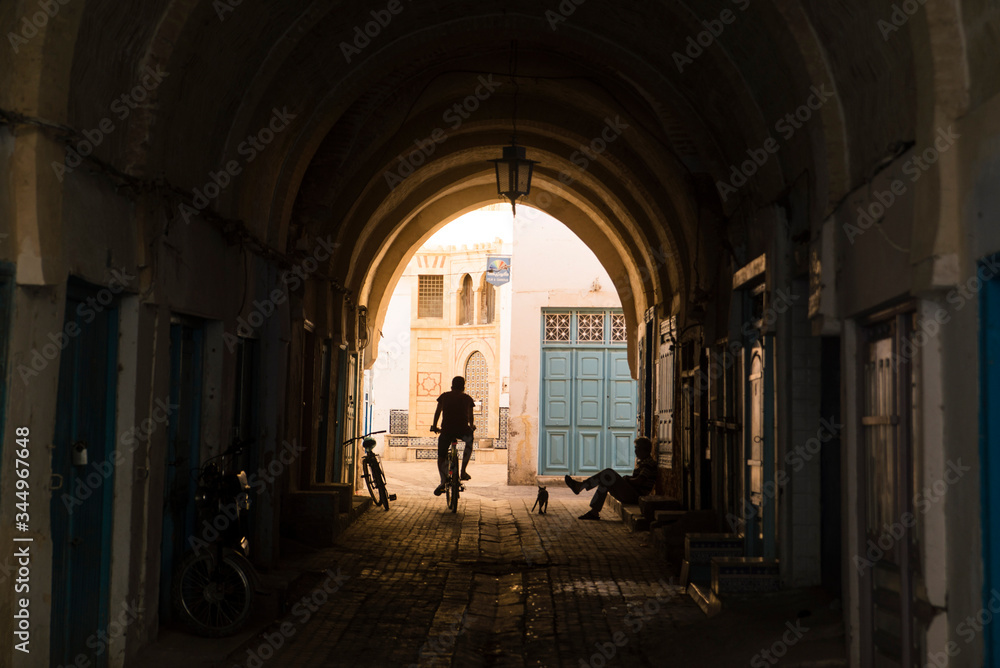 silhouette of a biker in old town tunisia