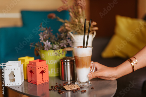 Close up of woman s hand and coffee on the table at caffee shop