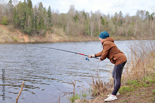 woman with fishing rod on the river
