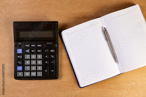 Calculator and business organizer, notebook or planner with silver bolpoint pen.