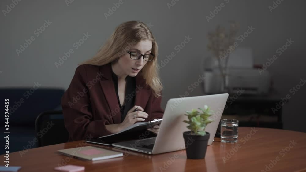 Businesswoman making video call to business partner using laptop, looking at screen wearing pods and smiling. Online meeting. Tutor. Businesswoman making video call to business partner using laptop, looking at screen wearing pods and smiling. Online meeting. Tutor.