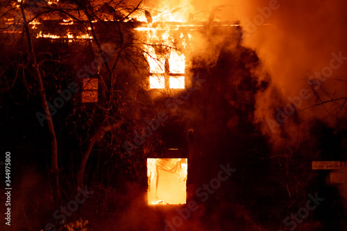 Fire, burning old house at night, flames engulfed the entire house