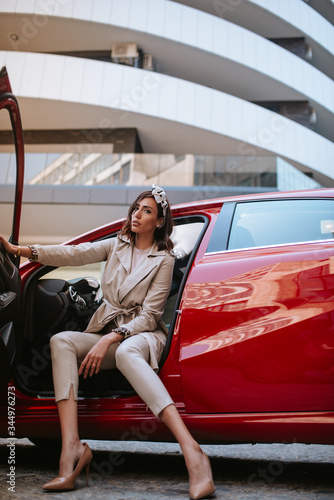 Beautiful caucasian businesswoman sitting in her red car © Dragica