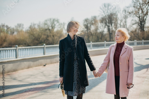 Mother and daughter spending time together. First the drink tea in the cafe  then go for a walk.